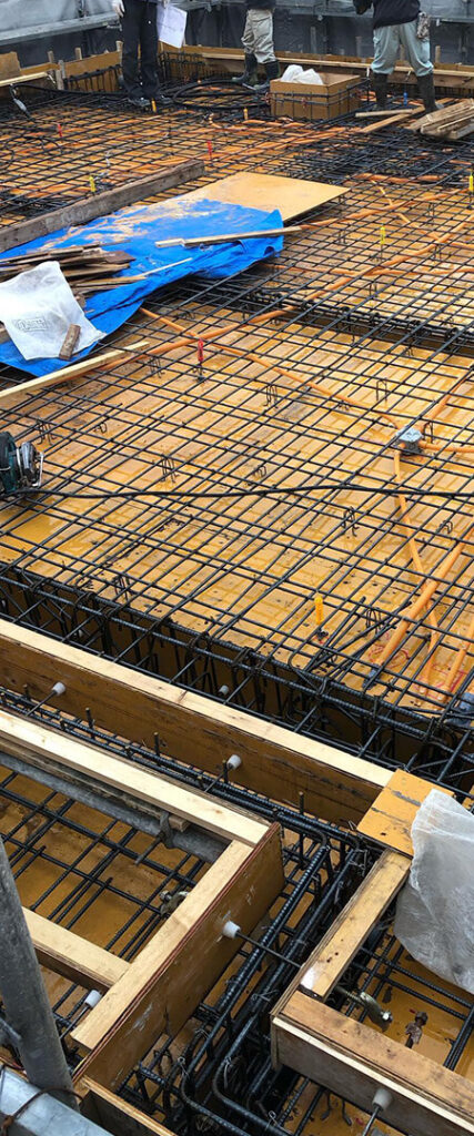 住宅基礎工事現場で鉄筋を組む作業の様子