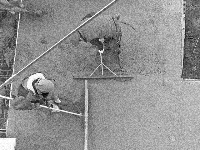 職人が土間コンクリートを均している様子